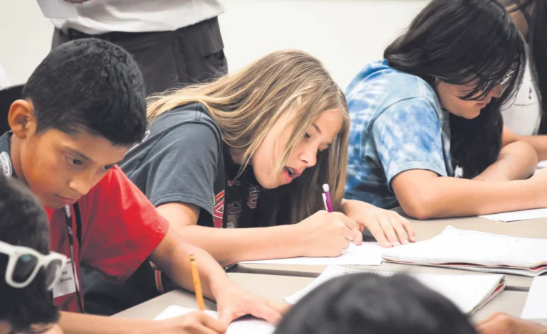 Children writing in a classroom during an activity illustrating the importance of City of London SEND support for young learners.
