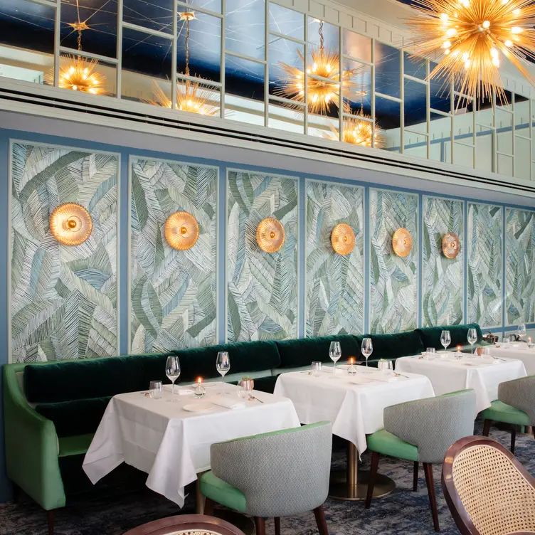 Dining room at Tom Brown at The Capital in Knightsbridge with sea green interiors, velvet seating and white table settings