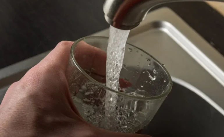 Glass being filled from a tap during the Tunbridge Wells water crisis, highlighting concerns over drinking water safety.
