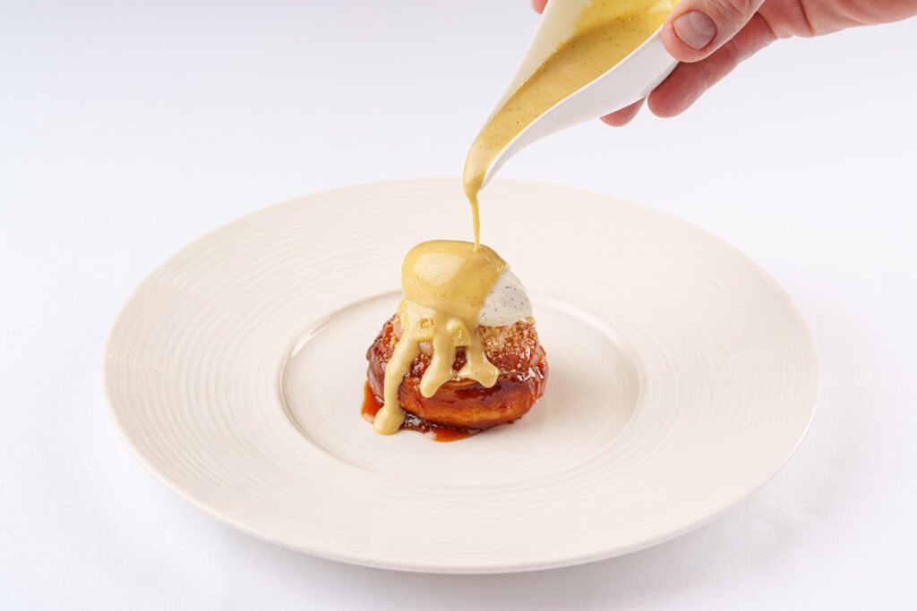 Quince Tatin dessert at Tom Brown at The Capital with vanilla mascarpone and whisky custard being poured.