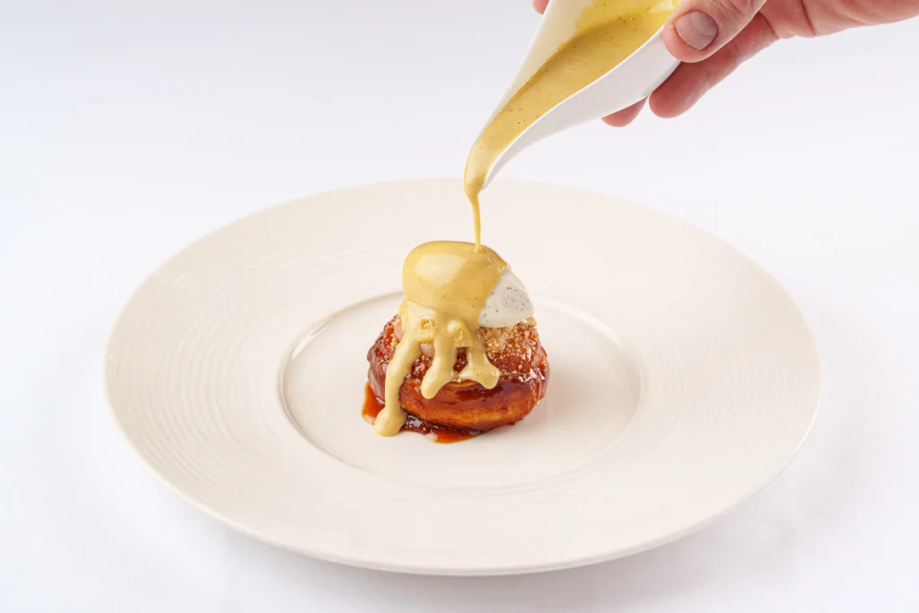 Quince Tatin dessert at Tom Brown at The Capital with vanilla mascarpone and whisky custard being poured.