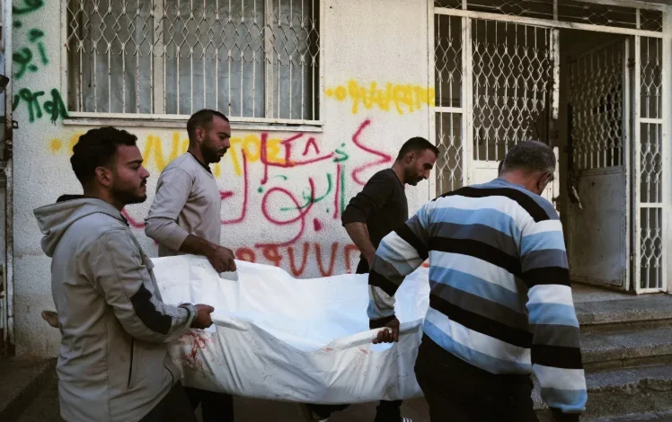 Civilians carry the body of a child in northern Gaza as violence continues during negotiations linked to Trump’s Board of Peace and the fragile ceasefire.