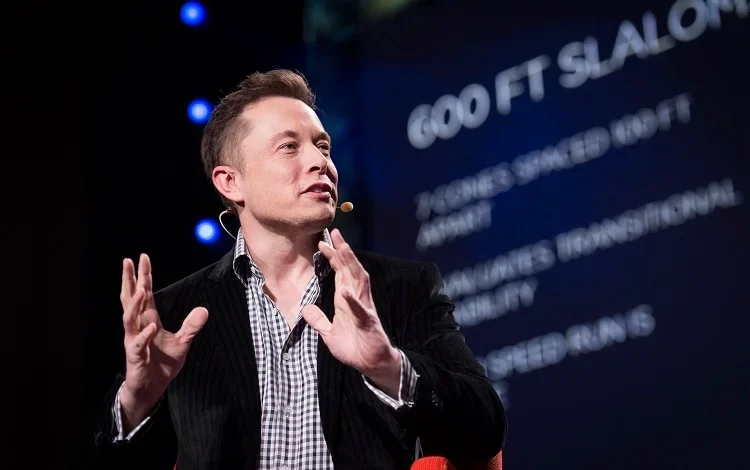 Elon Musk speaking at a technology event as UK US deepfake travel risk grows over regulation of X and its Grok AI system