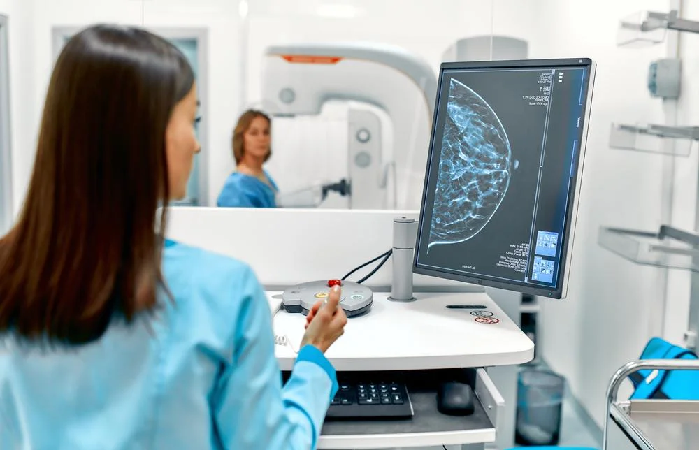 Breast cancer screening in London, showing a radiographer reviewing a mammogram image during a routine screening appointment. (1)