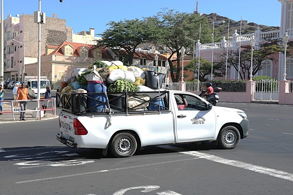 A loaded pickup makes its way through the streets of Mindelo, reflecting the rhythms of local trade.