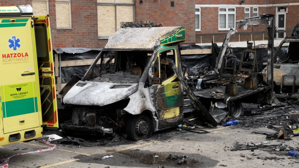 Golders Green ambulance arson aftermath showing burnt Hatzola vehicles outside synagogue