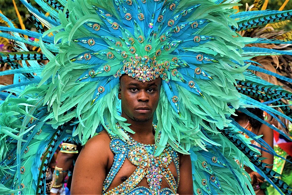 Notting Hill Carnival funding London with performer in feathered costume during parade