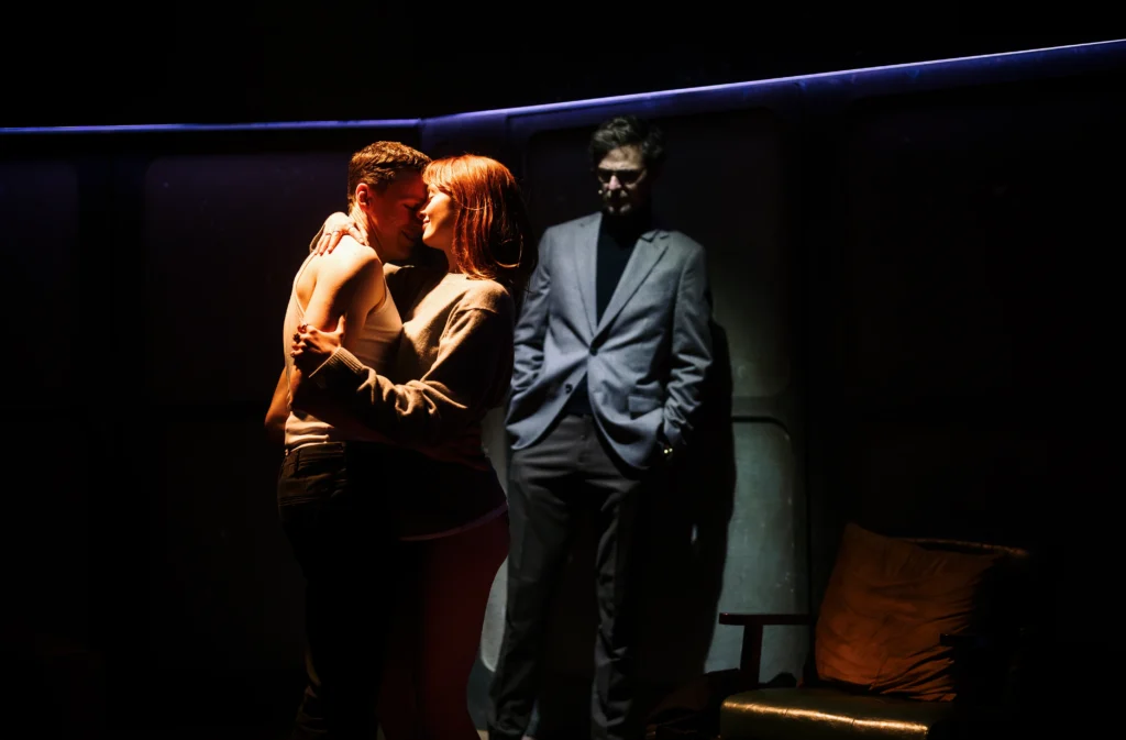 Stuart Thompson and Poppy Gilbert in Flyby at Southwark Playhouse Borough, with Rupert Young in the background. Image Credit | Alex Brenner