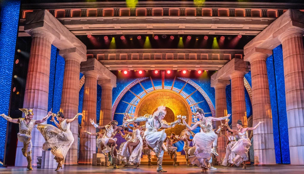 The ensemble performs a scene from Hercules at Theatre Royal Drury Lane, set against the stylised Mount Olympus backdrop. Photo by Johan Persson ©Disney