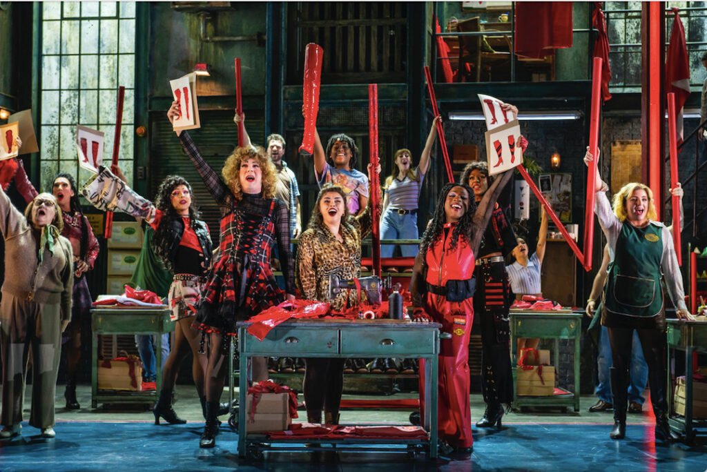 The factory floor erupts into life as the workers take pride in what they’re making in Kinky Boots at the London Coliseum. (Image Credit | Matt Crockett)