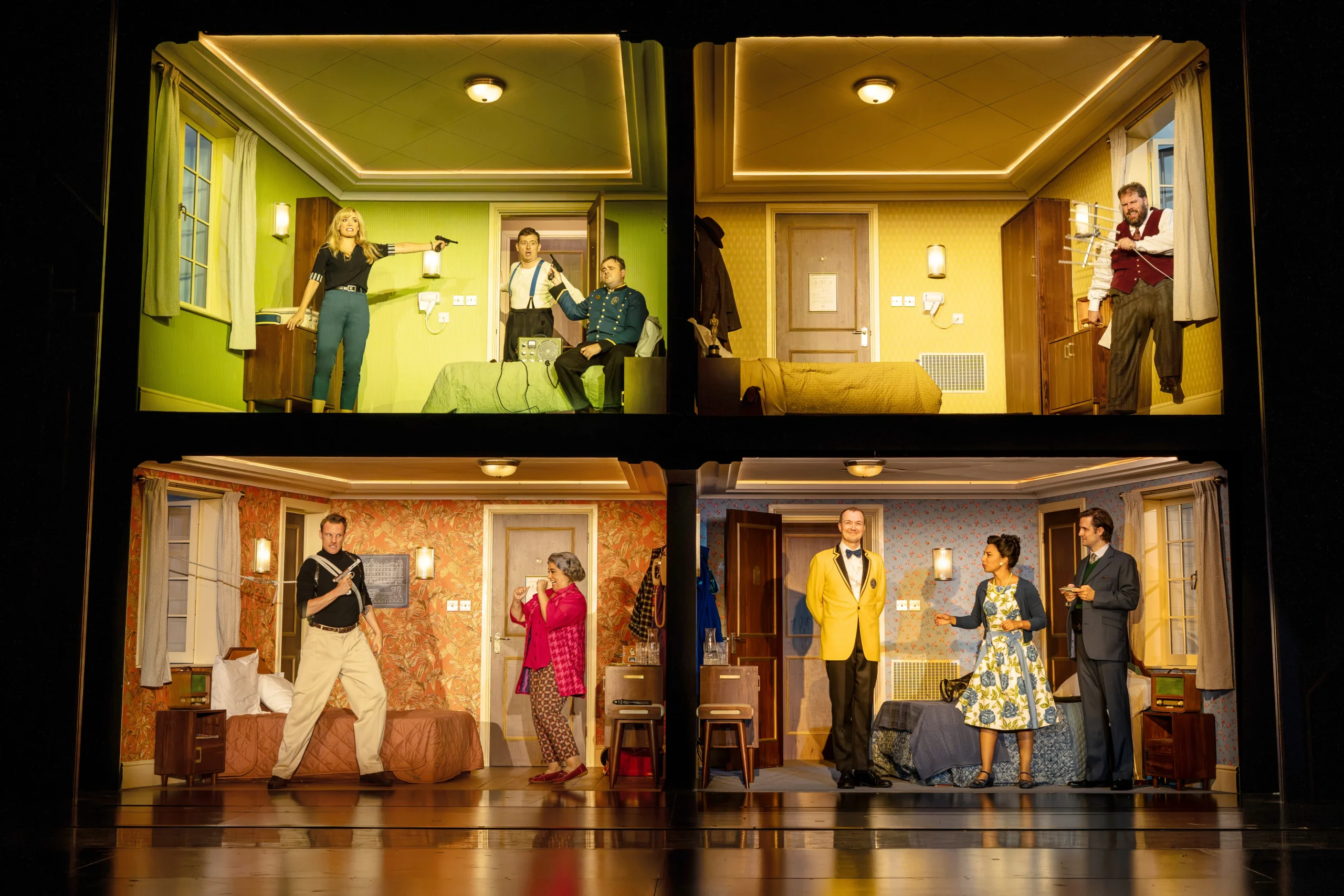 Comedy About Spies dollhouse hotel set with four rooms shown at once at the Adelphi Theatre