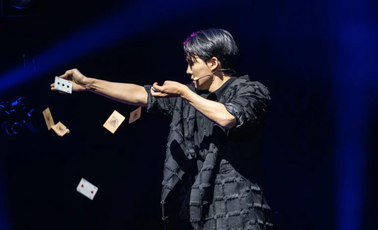 Now You See Me Live magician, Eden Choi, throws cards mid-performance at the London Coliseum