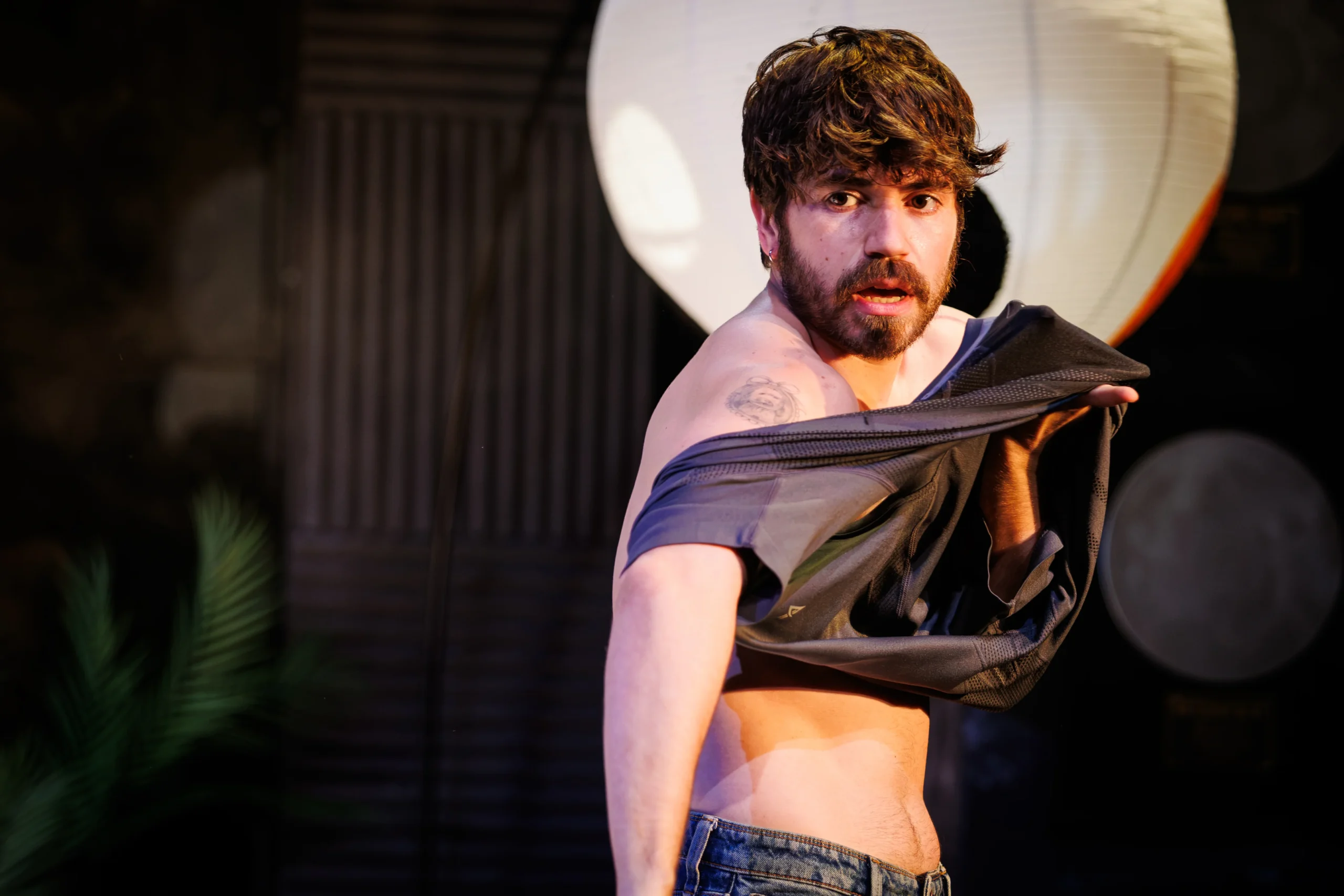 Noah Galvin mid costume change on stage in Hit Machine at Soho Theatre