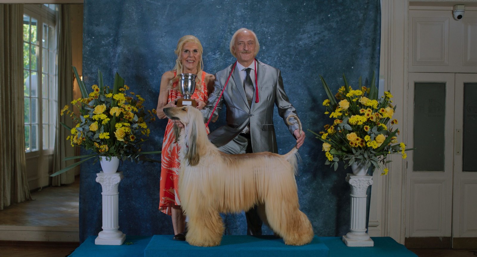 Prince film still, an Afghan Hound show champion flanked by trophy and owners