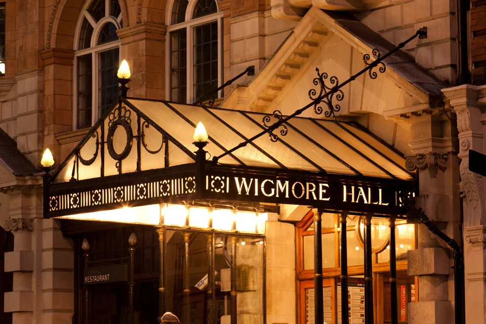 Illuminated Wigmore Hall entrance canopy at night, London concert venue featured in Anthony Hopkins Life Is A Dream review